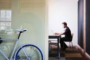 Mann sitzt am Tisch vor Laptop Mann sitzt am Tisch vor Laptop